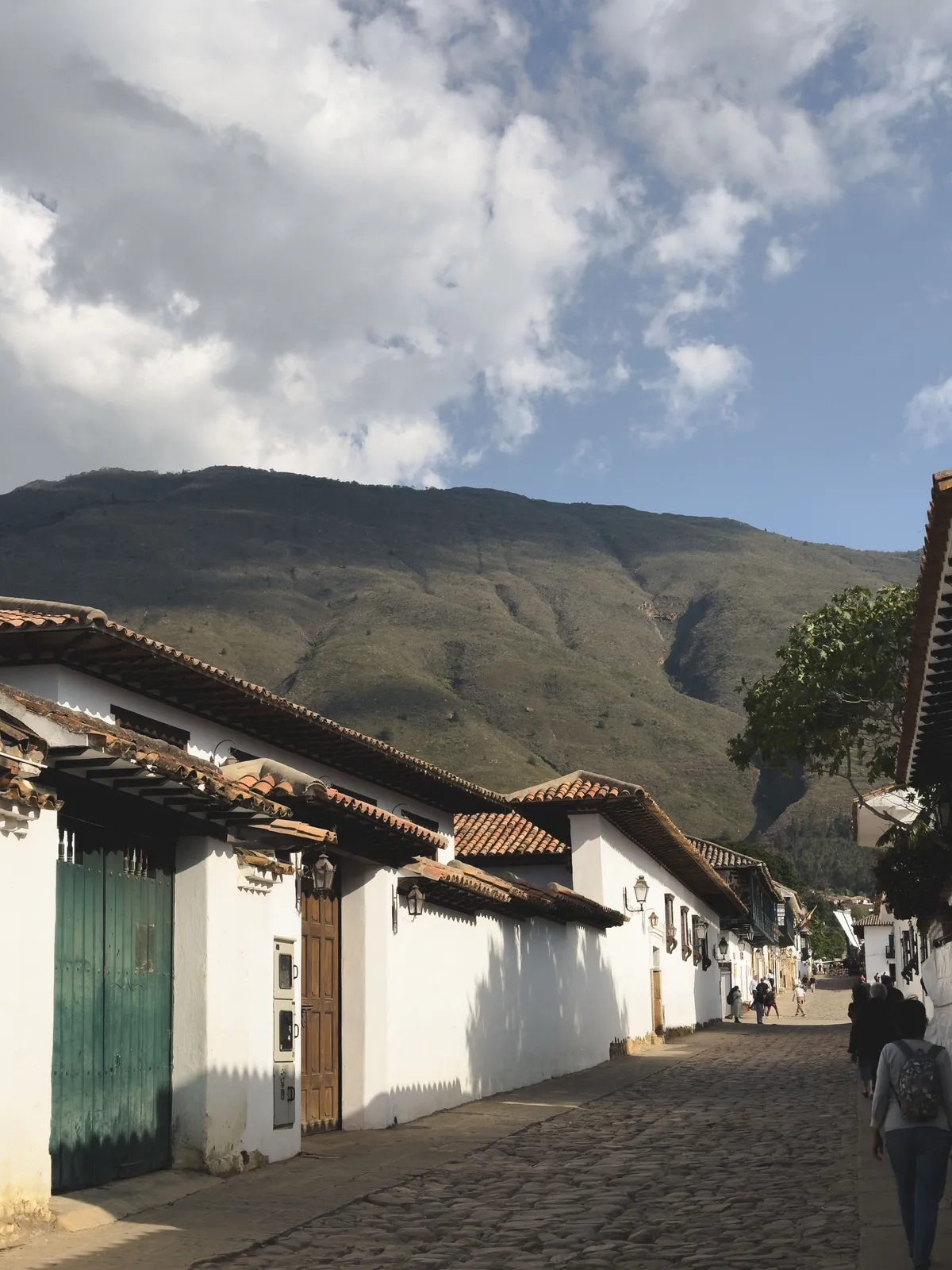 Calle empedrada de Villa de Leyva con las casas blancas y la montaña al fondo